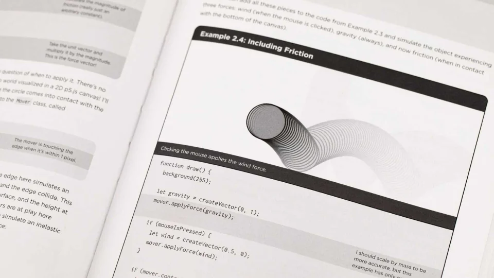 Open book of The Nature of Code by Daniel Shiffman with a sample snippet of code.